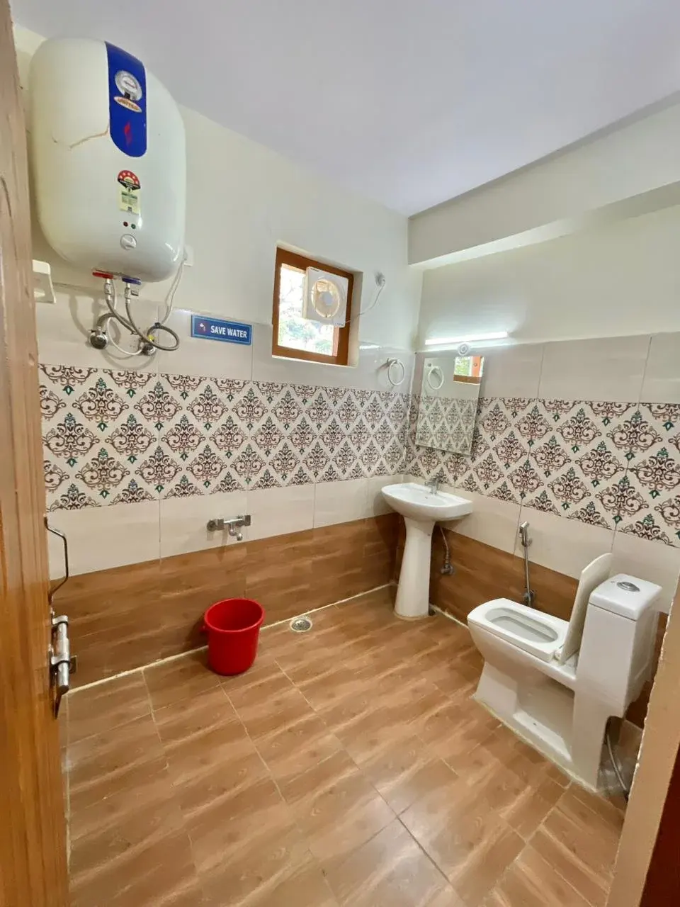 Clean, modern bathroom with patterned tiles and wooden-style flooring