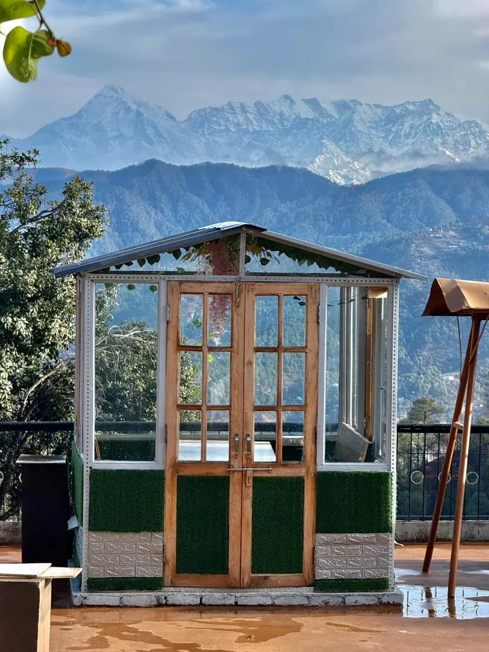 Close-up of a charming wooden gazebo set against snow-capped peaks