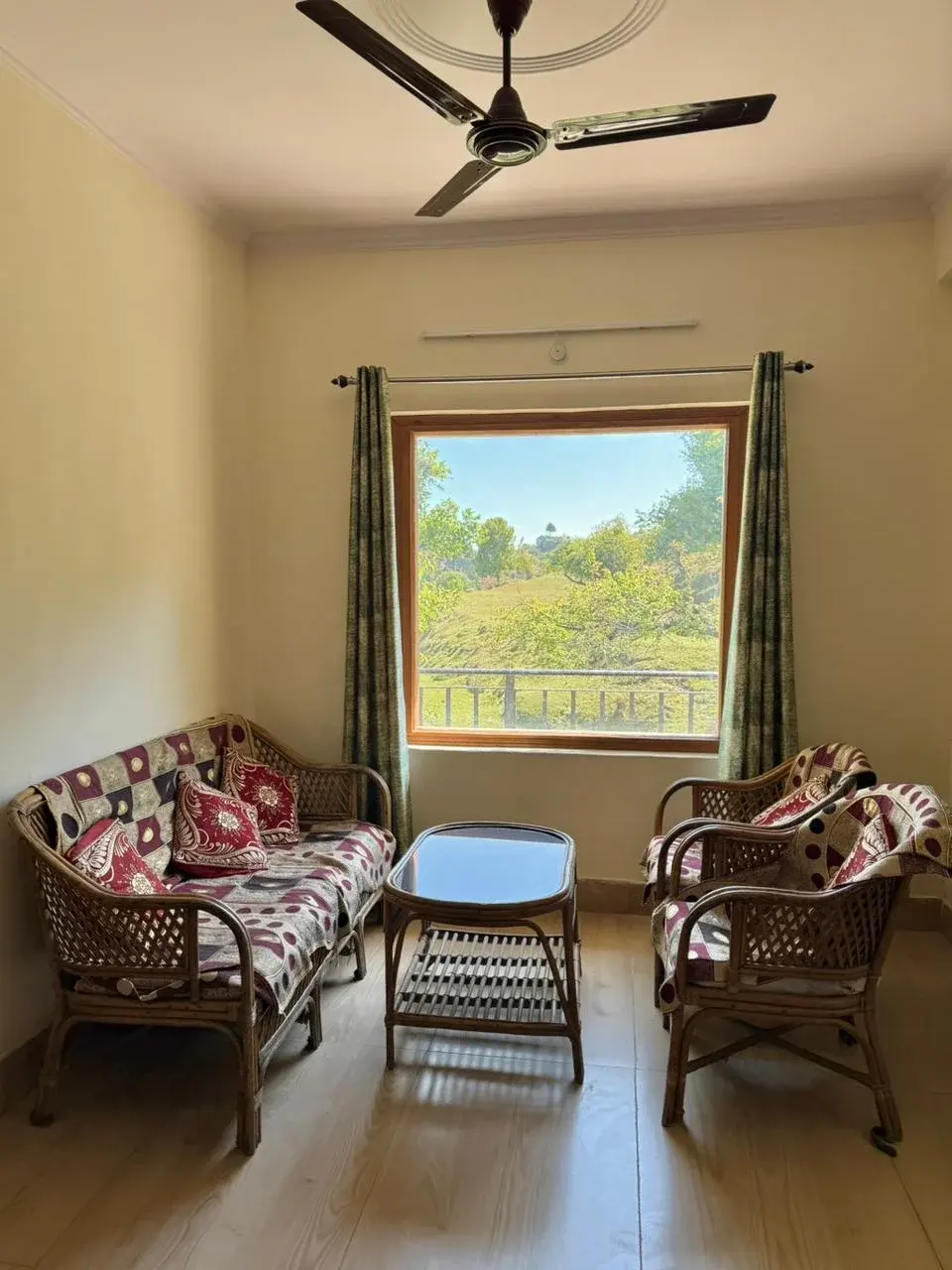 Cozy sitting area with floral sofas and a window framing the lush outdoor scenery