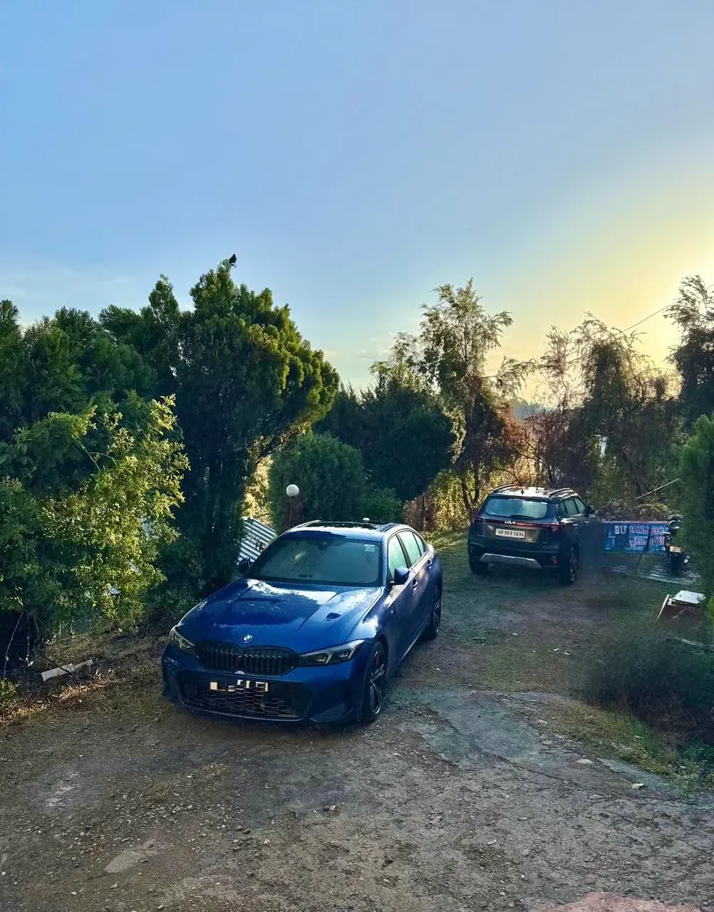 Hotel parking area surrounded by dense trees during a beautiful mountain dusk