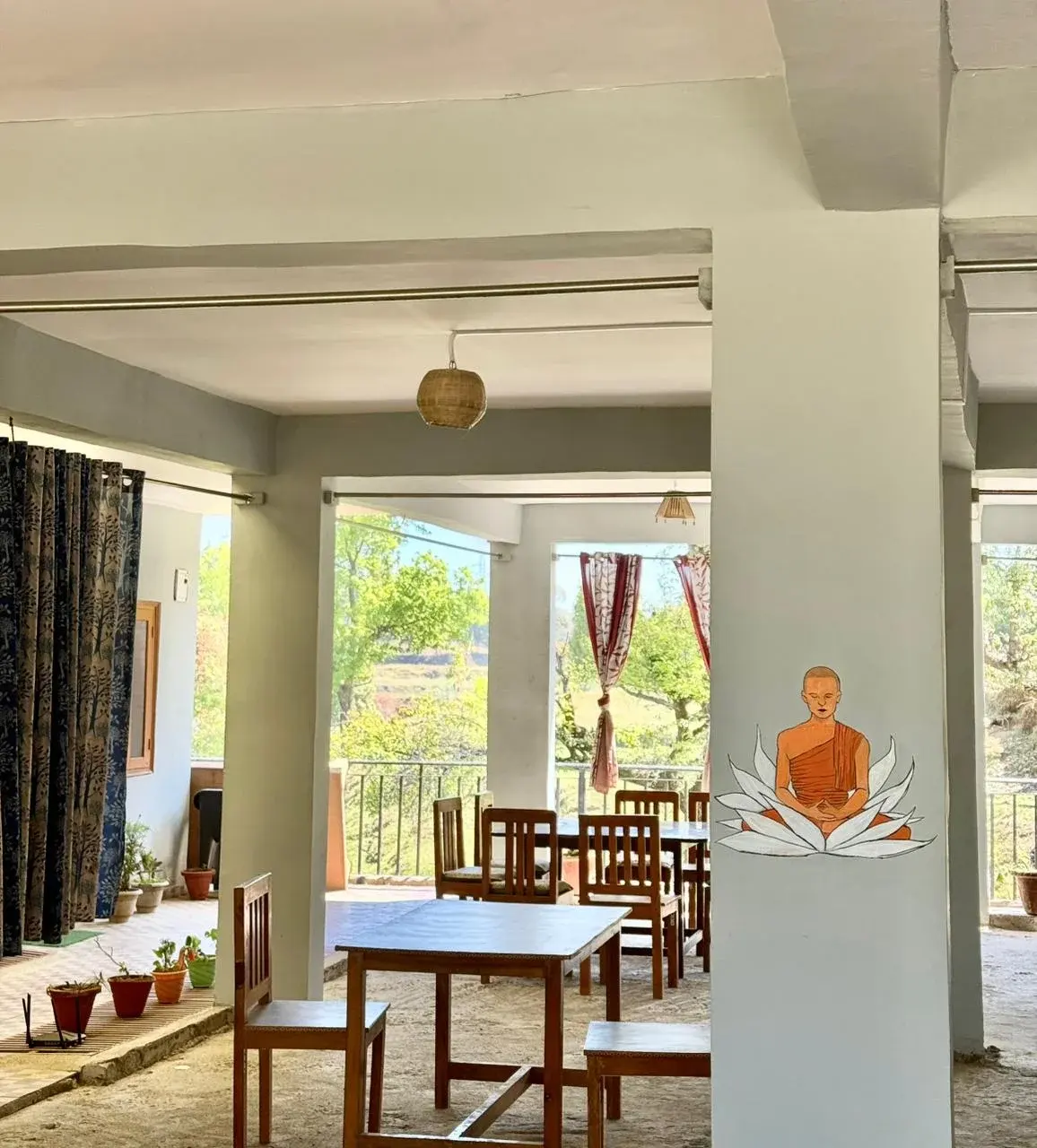 Open-air restaurant dining area offering meals with a view of the hills