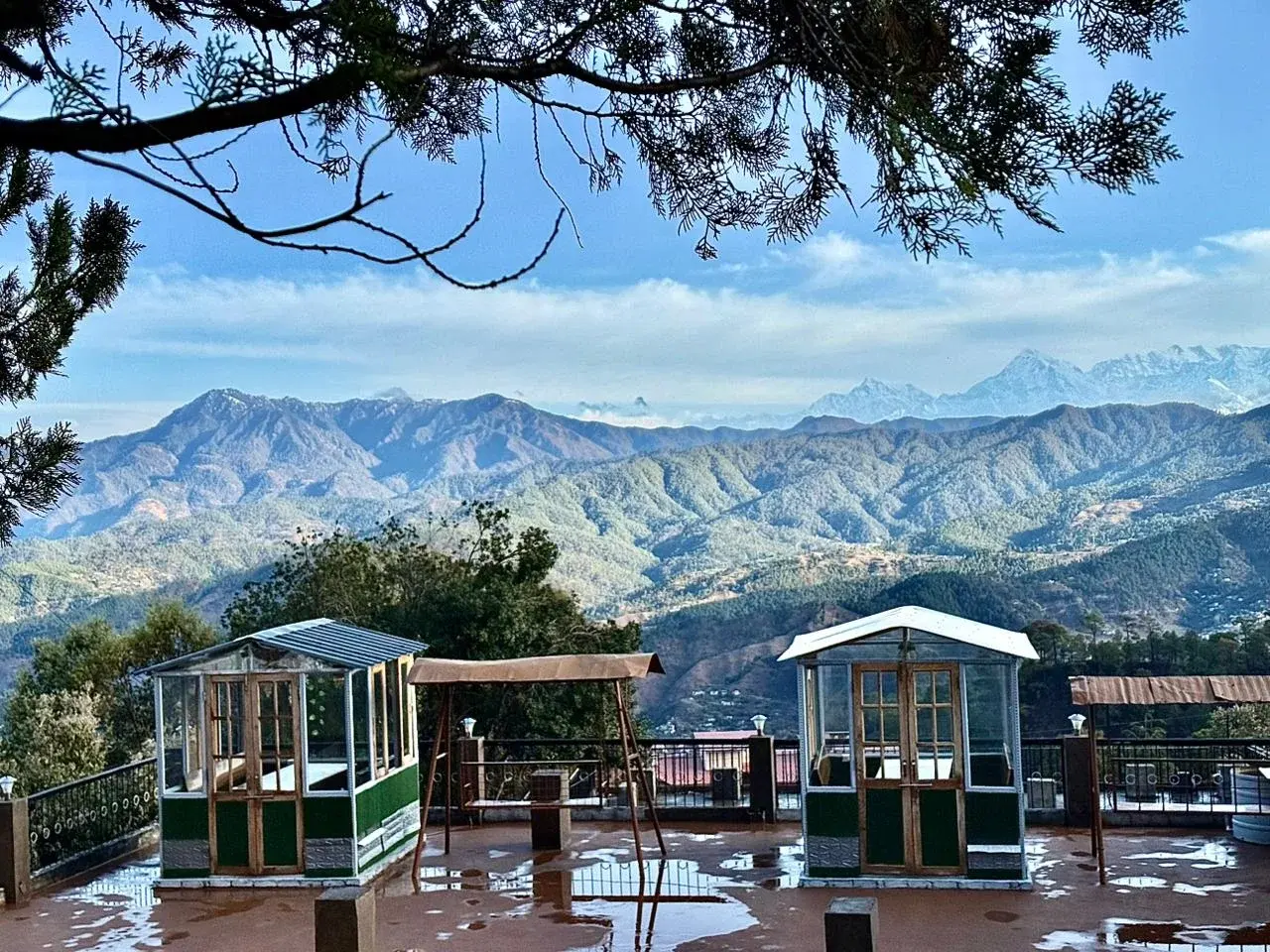 Scenic Himalayan mountain range with green gazebos in the foreground