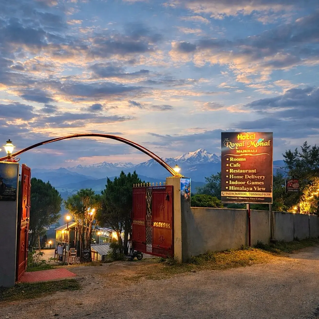 Sunrise at Hotel Royal Monal’s entrance, surrounded by lush greenery with snow-capped Himalayan peaks in the backdrop.